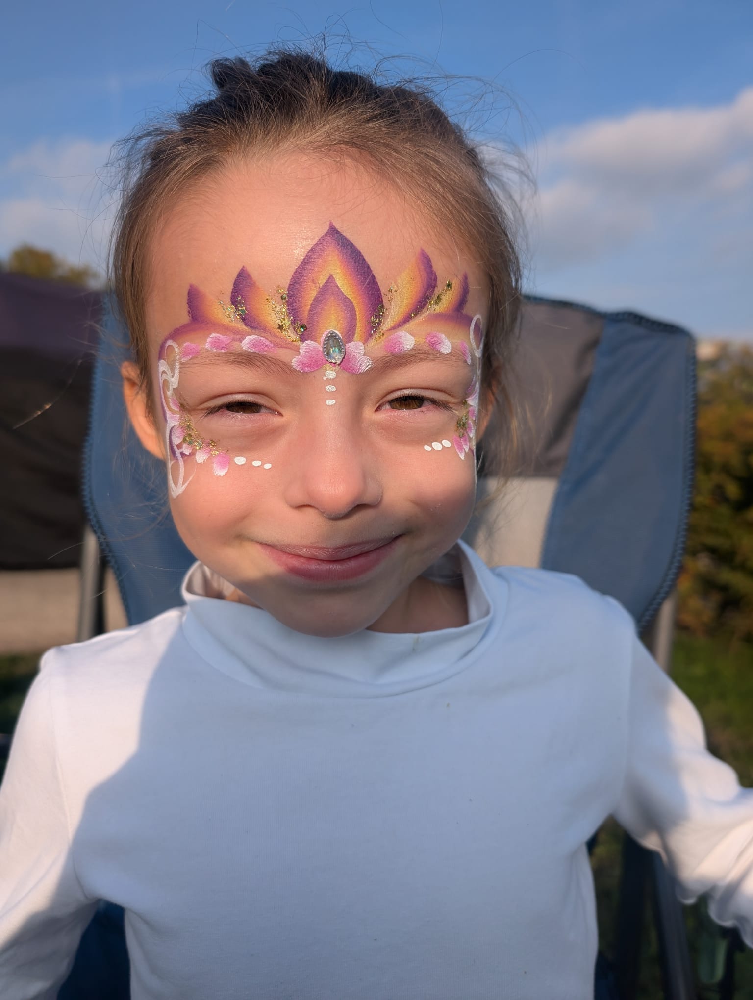 Pink and gold flame tiara face paint for a girl