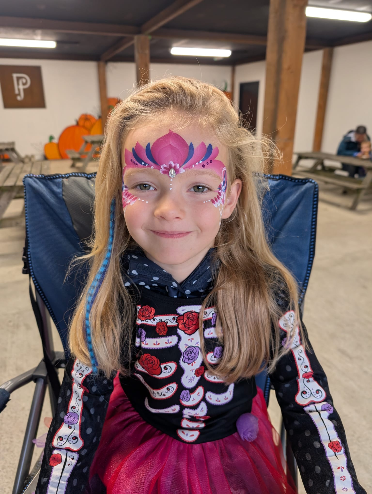 Pink princess crown face paint with butterfly wing cheeks