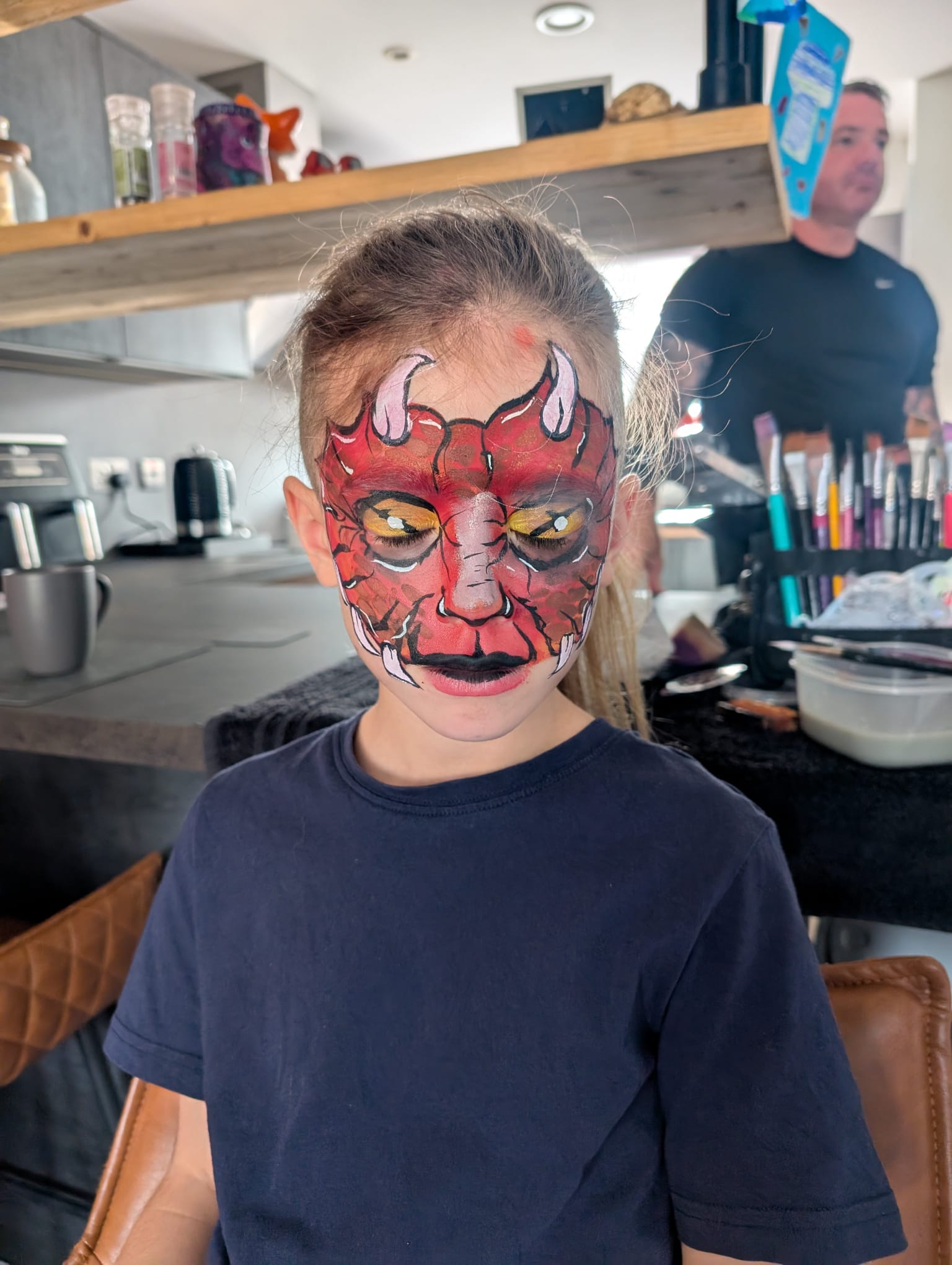 Red devil face paint for a boy