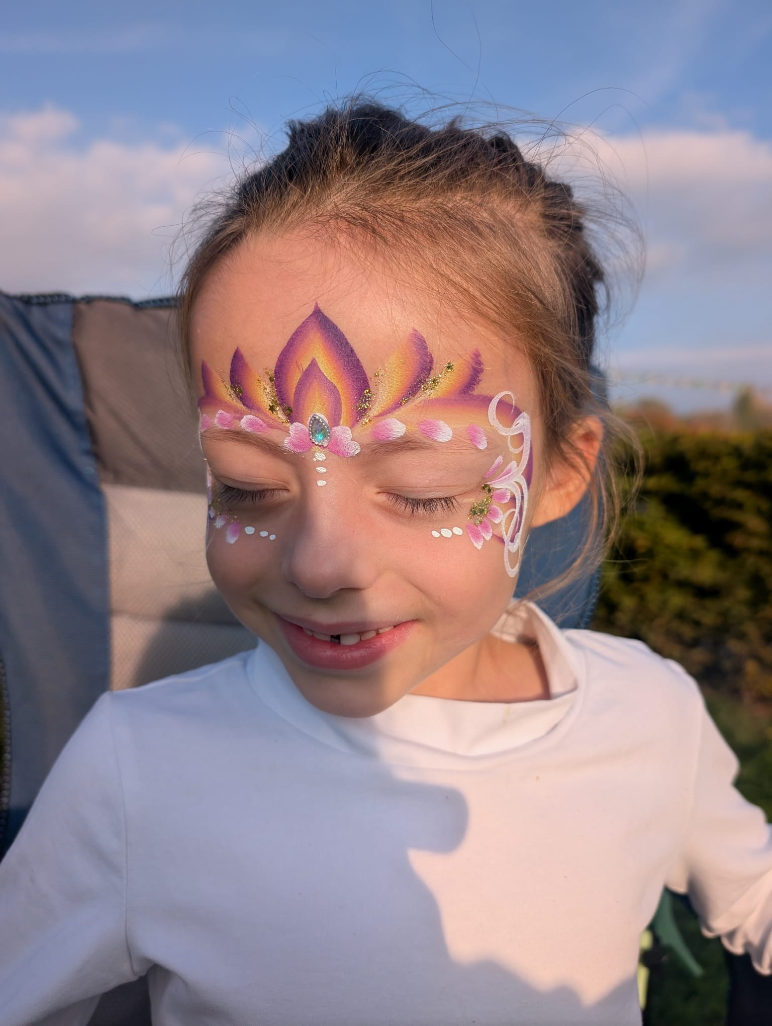 Red devil face paint for a girl, side view