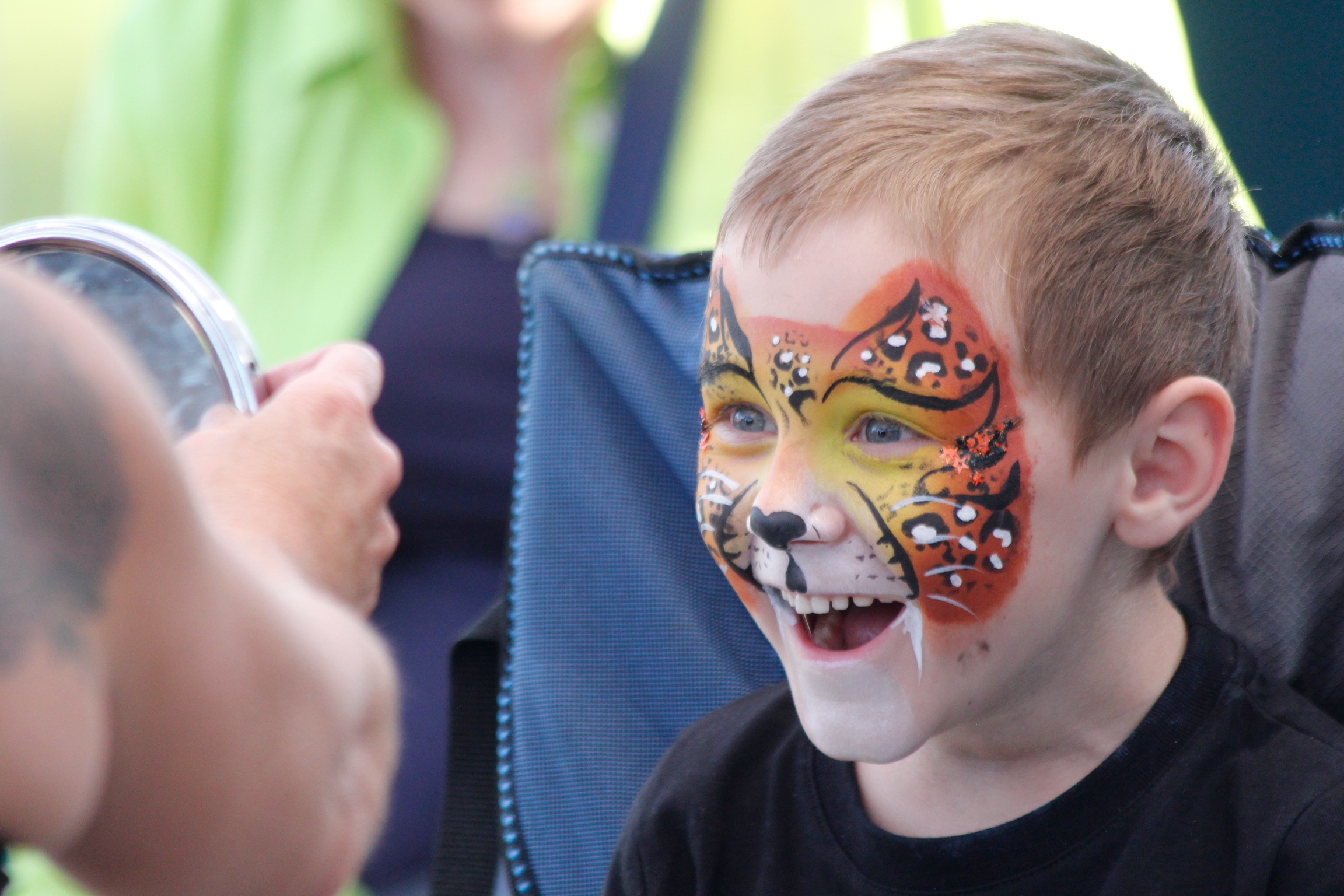 Tiger print face paint design, laughing boy at a Horsham festival.